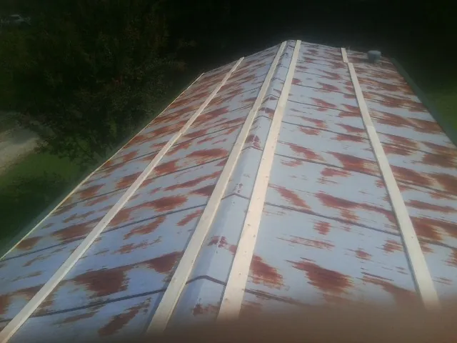 Rusted metal roof panels with new wood purlins before replacement — Storm Damage Roof Repair in Syria by Roofing Brothers